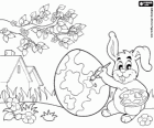 Todo preparado para la llegada de la Pascua, un conejo pinta un huevo de Pascua